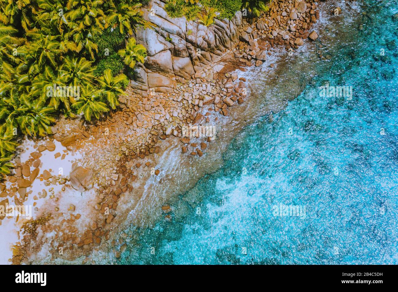 Aerial drone helicopter view of crystal clear turquoise water and amazing granite rocks. La Digue Island Seychelles. Stock Photo