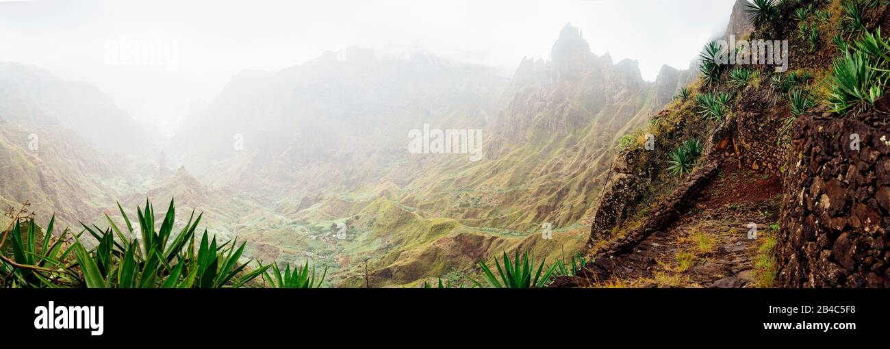 panorama of Xo-Xo valley surrounded by harsh mountain peaks. Steep walk path covered by yucca plants lead down to Ribeira Grande. Santo Antao island, Cape Verde. Stock Photo