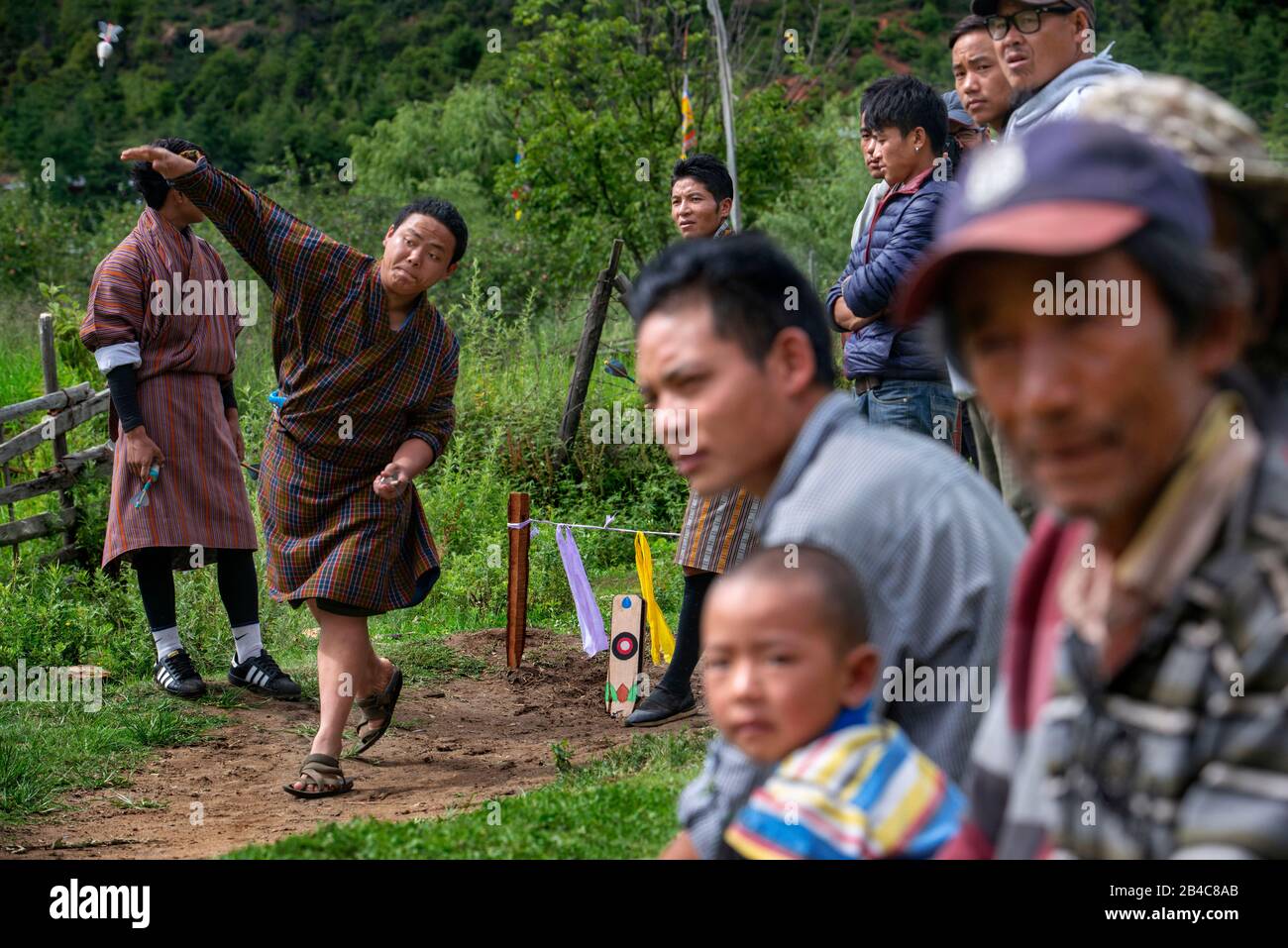 Men playin Khuru darts traditional Bhutanese sport of throwing large darts outdoors in Paro Bhutan Stock Photo