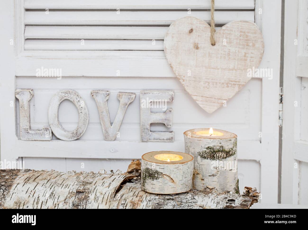 rustic winter deocoration in a white interior, with with homemade birch candle holders, word love in wooden letterns and heart Stock Photo