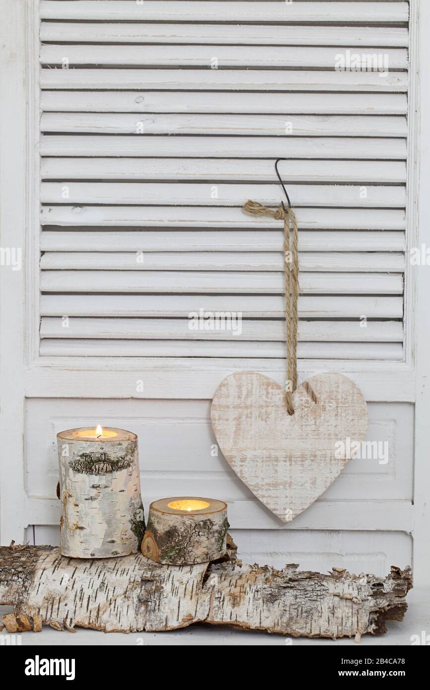 rustic winter deocoration in a white interior, with with homemade birch candle holders and wooden heart Stock Photo