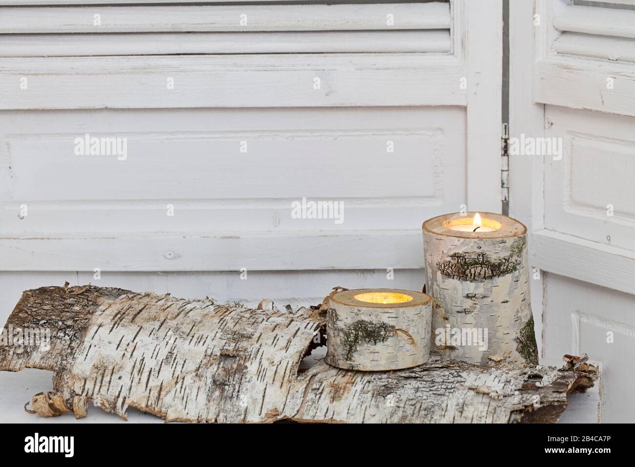 rustic winter deocoration in a white interior, with with homemade birch candle holders and copy space Stock Photo