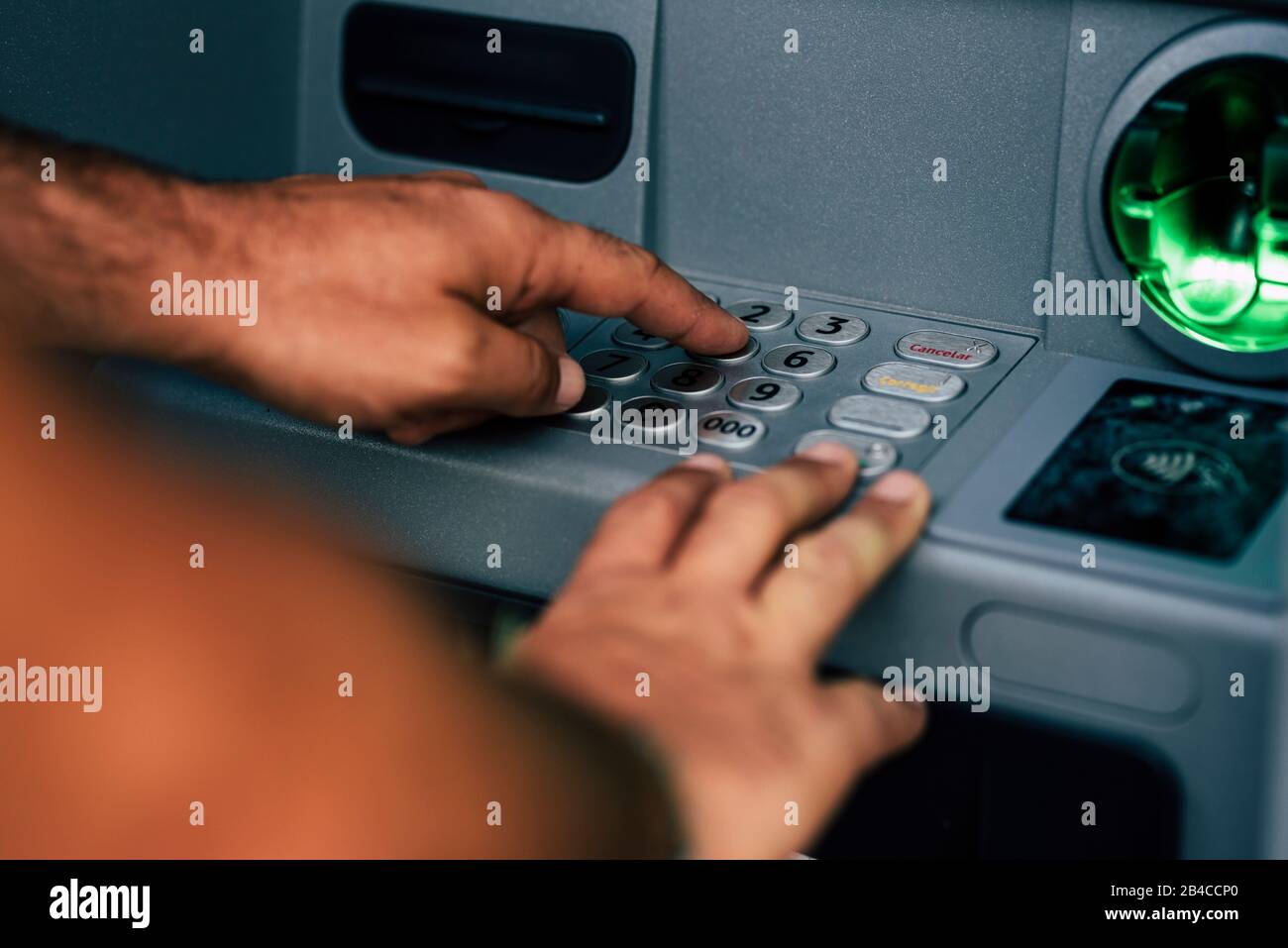 Close up of man hands typing the secret security pin code for atm bank card to withdraw money - concept of technology and economy Stock Photo