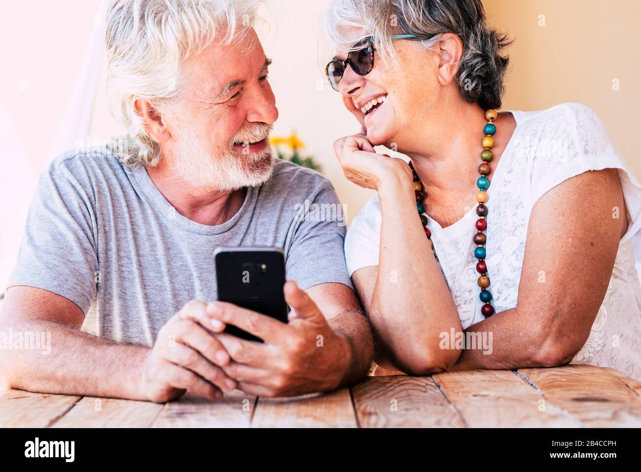 Couple of old happy cheerful people caucasian senior man and woman smiling together each other with love - concept of forever together life - joyful for aged family Stock Photo