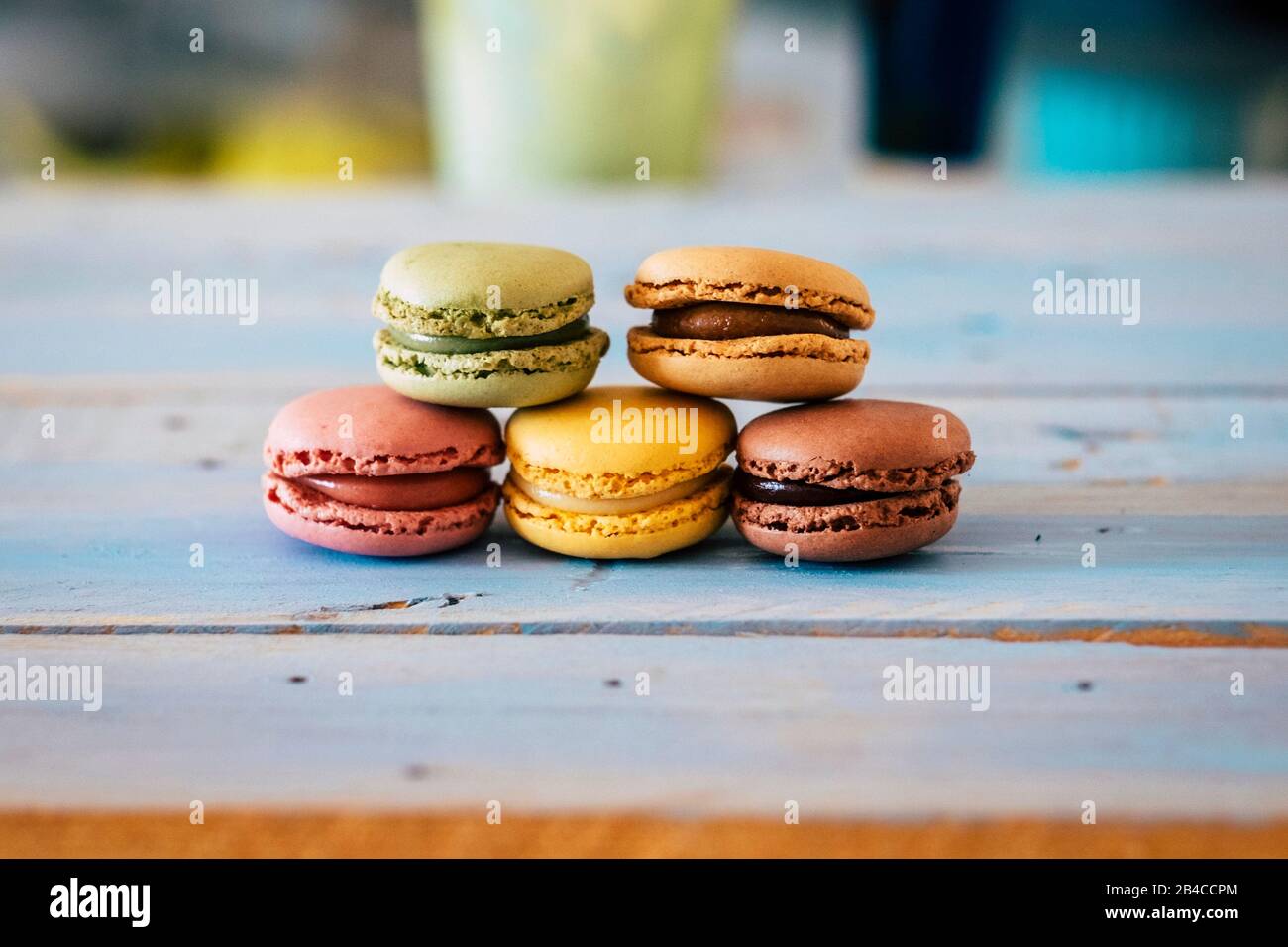 Close up of tasty bakery macarones on a blue woden rustic table - sweet cakes made from bakery chef with cream and chocolate flavours Stock Photo
