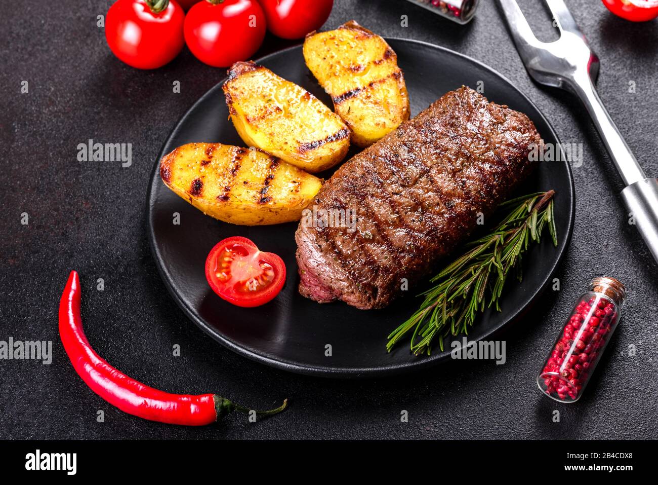 Ribeye steak with potatoes, onions and cherry tomatoes. Juicy steak