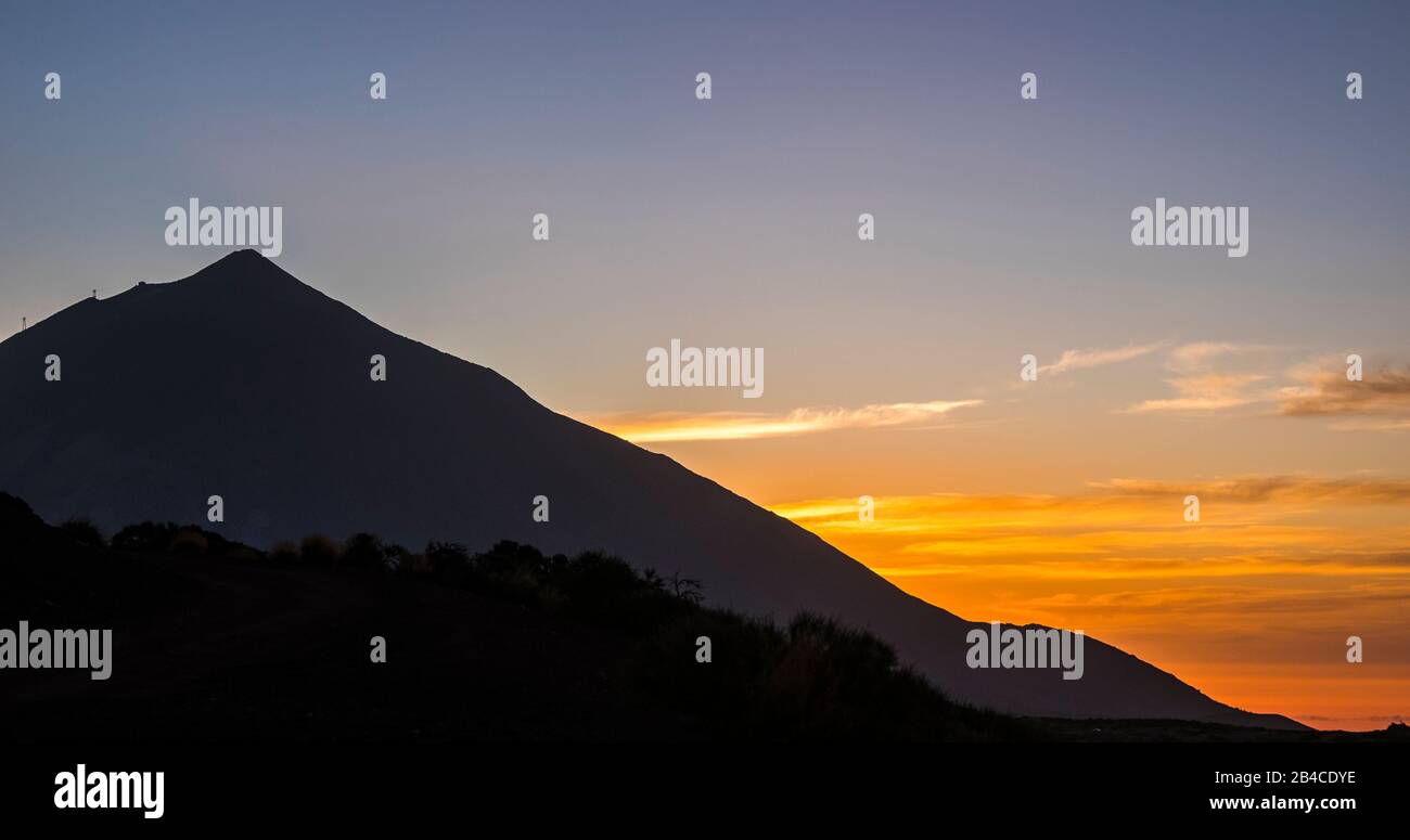 Sunset or sunrise beautiful landscape moment at the mountain - high peak vulcan and coloured sunlight in background - black silhouette - beauty of outdoor nature Stock Photo