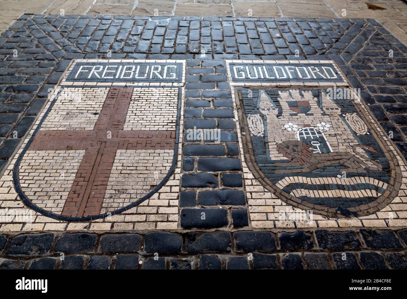 The twin town coats of arms of Guildford and the German city of Freiburg im Breisgau set under the Tunsgate Arch in Guildford, Surrey. Stock Photo