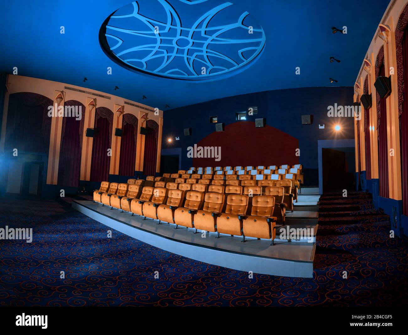 Large cinema theater interior with seat rows for audience to sit in