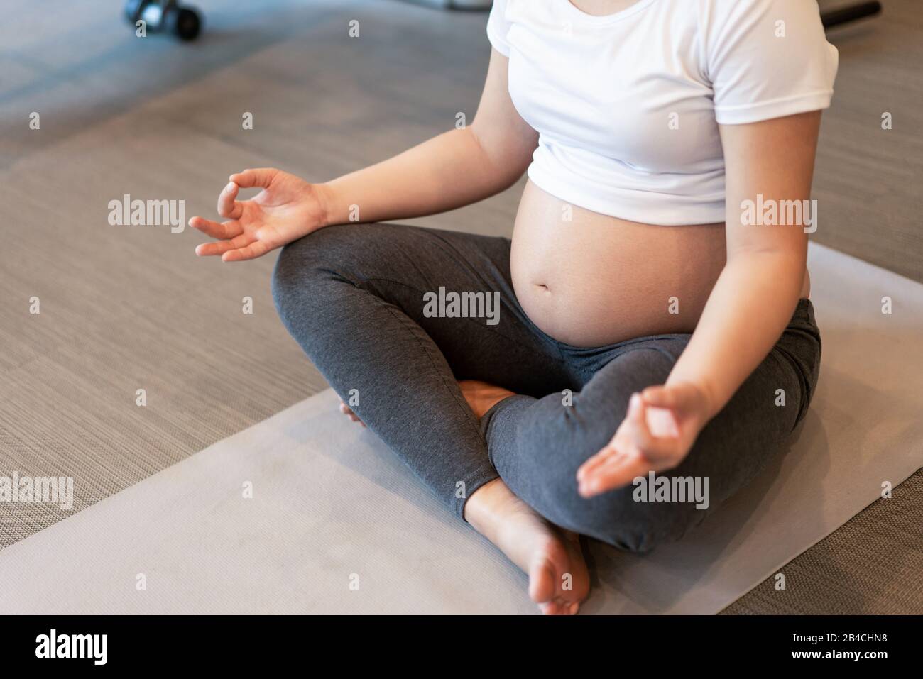 Active pregnant woman exercise in fitness center at yoga room. The