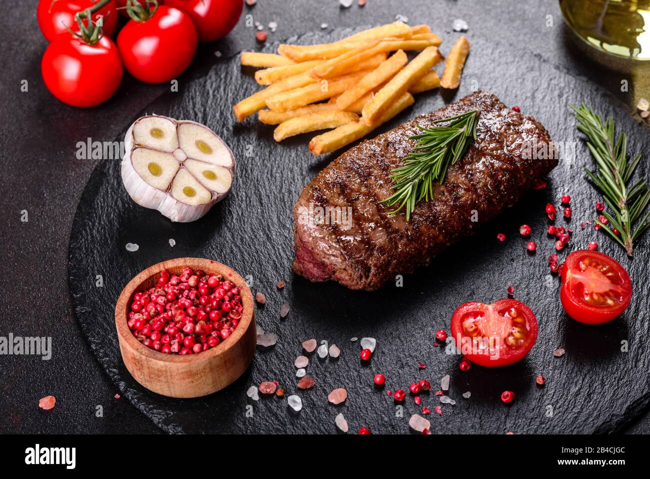 Ribeye steak with potatoes, onions and cherry tomatoes. Juicy steak