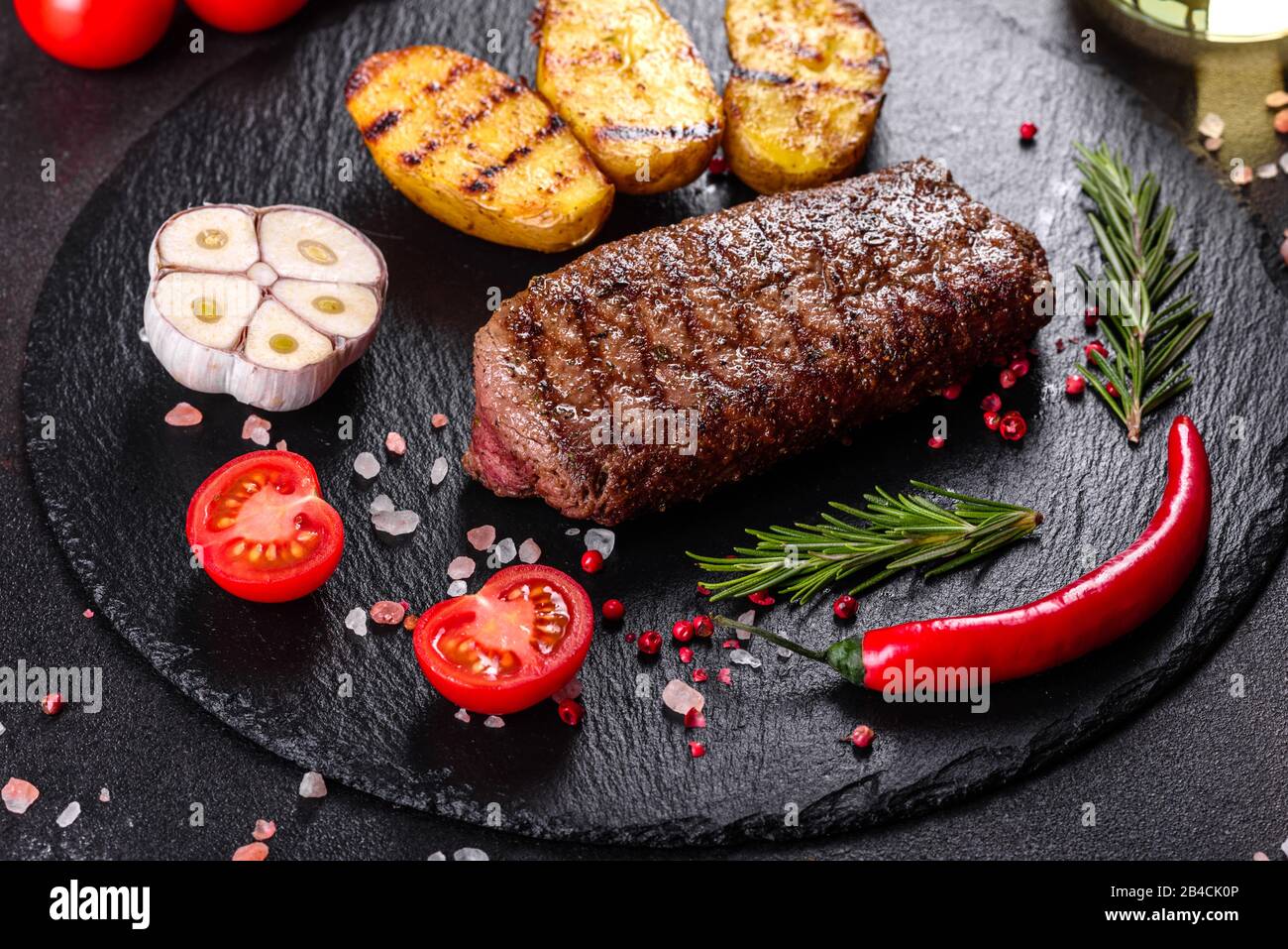 Ribeye steak with potatoes, onions and cherry tomatoes. Juicy steak