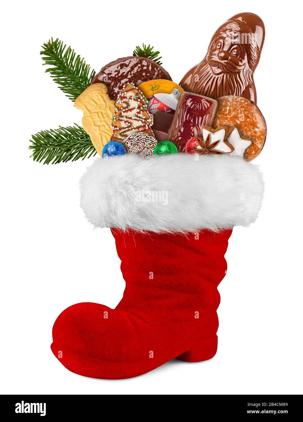 Red st nicholas day boot filled with chocolate santa claus cookies gingerbread cinnamon stars orange and green fresh fir branches isolated on white ba Stock Photo