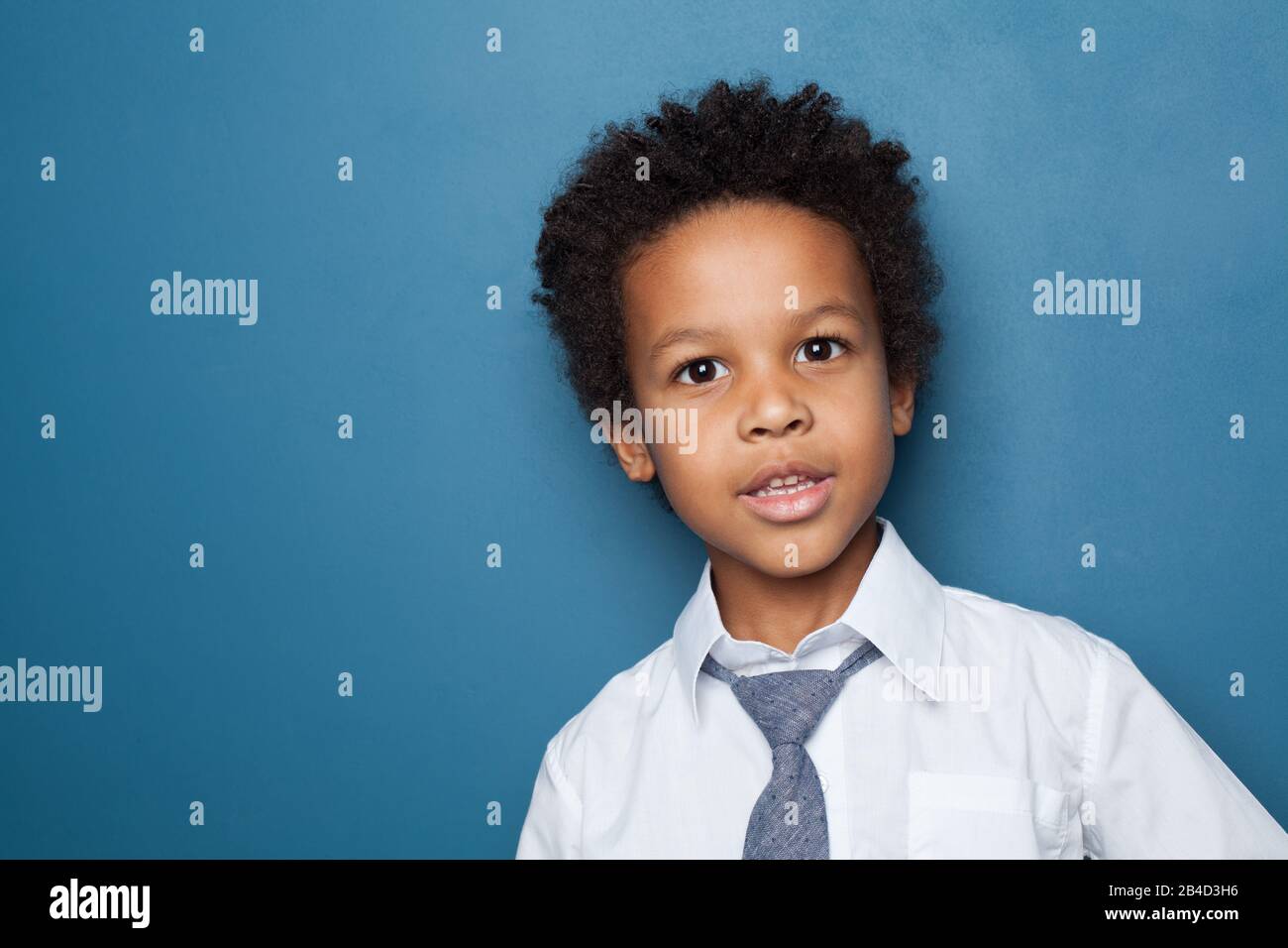 Little black child boy smiling and looking up on blue background Stock ...