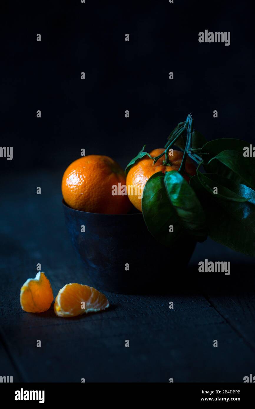 Mandarins on a dark background in a cup Stock Photo