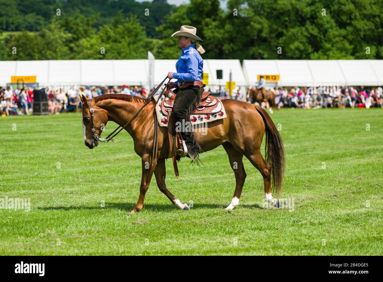 A female horse rider  in stetson hat with crowd behind, Cambridgeshire County Show, United Kingdom Stock Photo