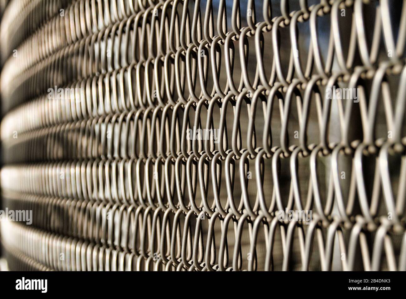 A close up view of a chain link fence creates an abstract pattern. Stock Photo
