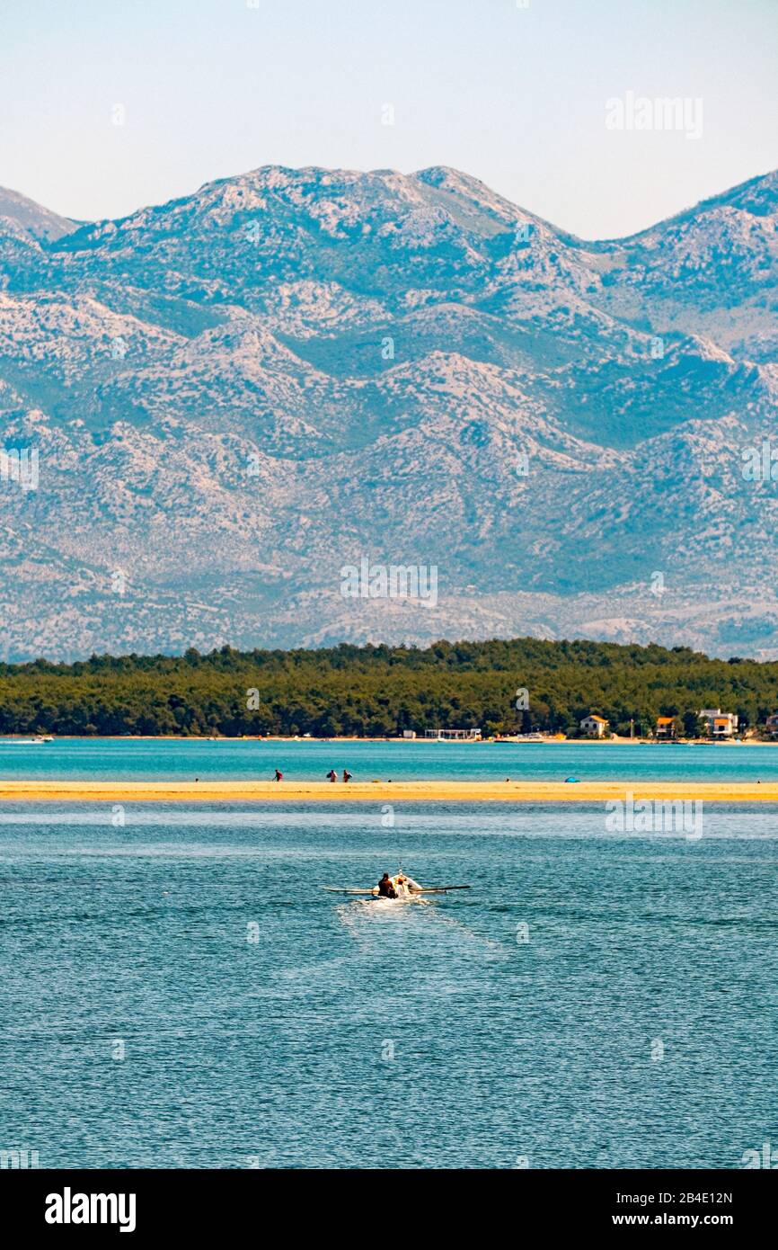 A boat on the sea in Nin Bay. In the background the Velebit mountain in Croatia. Stock Photo