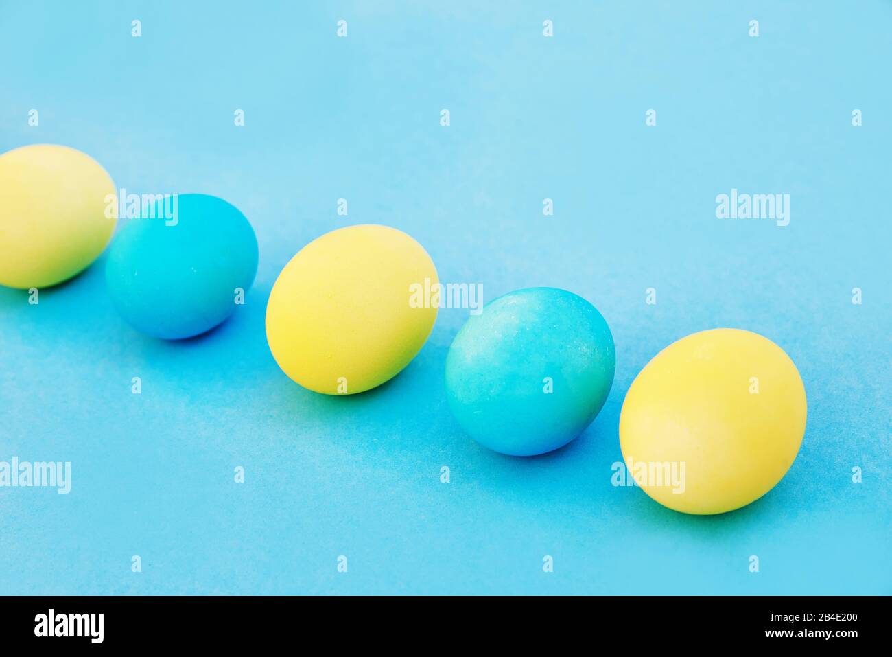 Easter blue and yellow eggs on blue background. Greeting Easter Spring Card Stock Photo