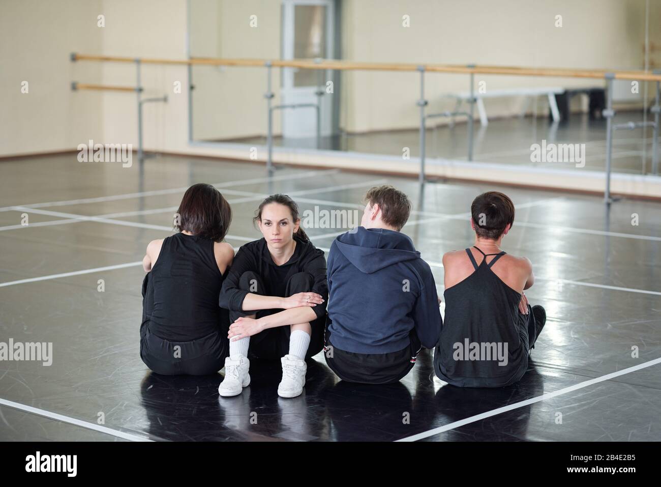 Young serious woman in costume looking at camera while sitting among