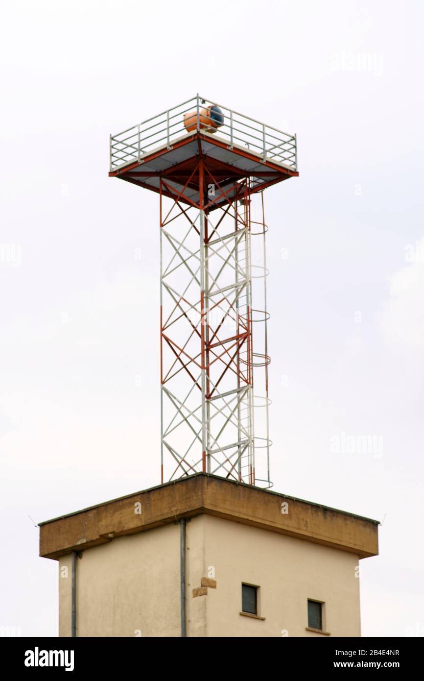 A disused watchtower with a floodlight on a disused airport area. Stock Photo