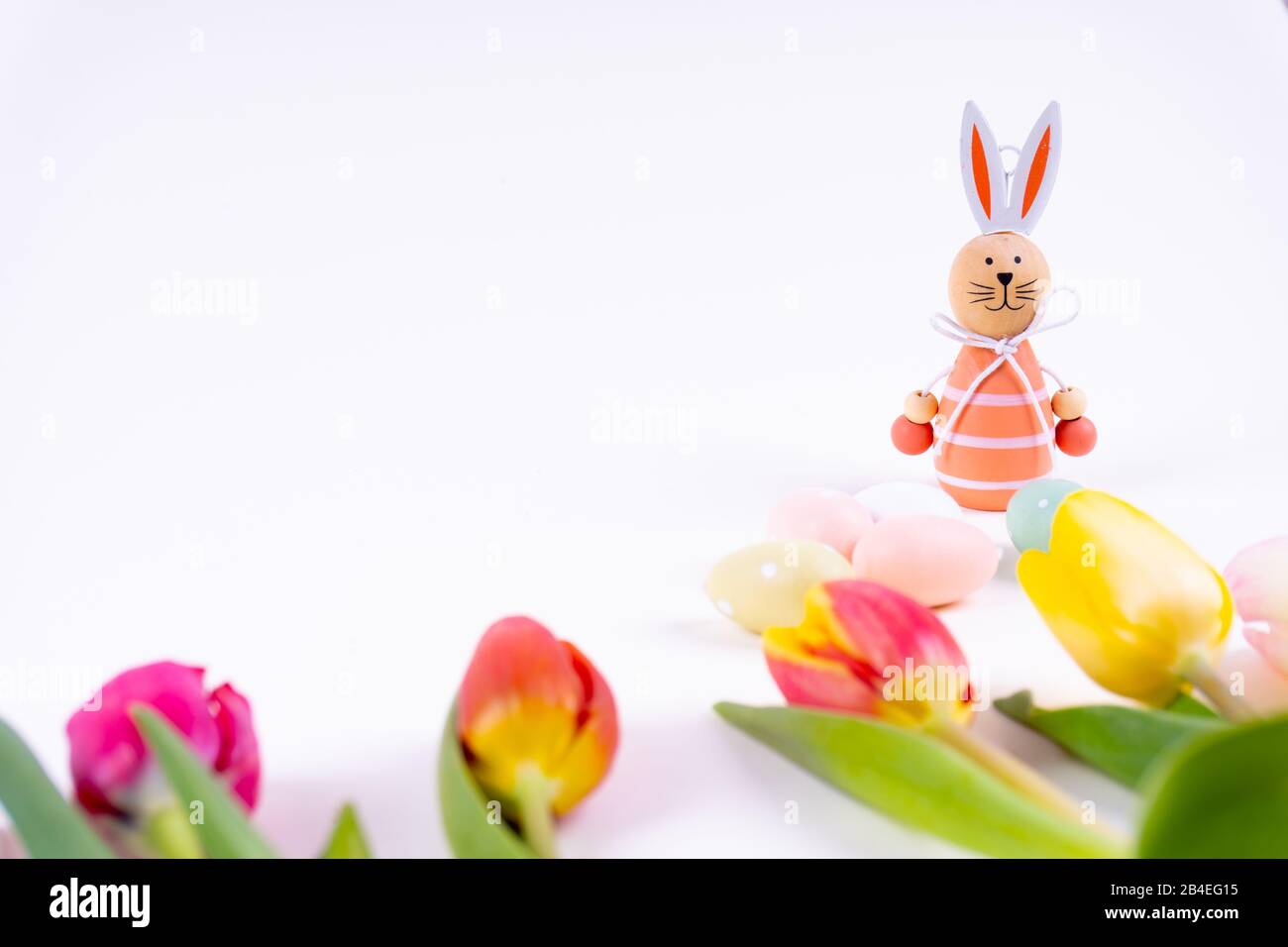 Colorful tulips laying in a row with easter eggs and a easter bunny on ...