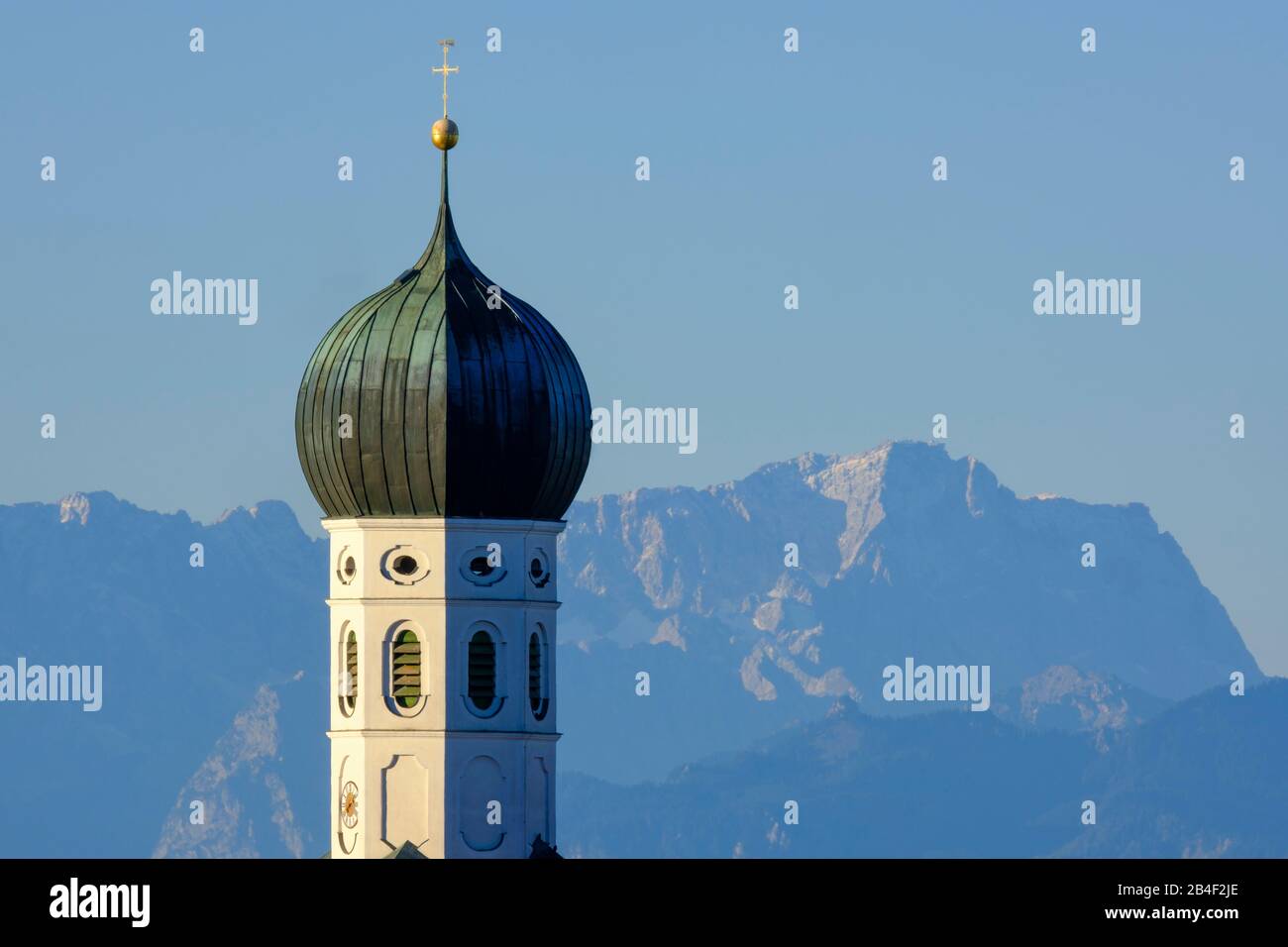Onion tower of the parish church of the Assumption in Münsing, behind ...