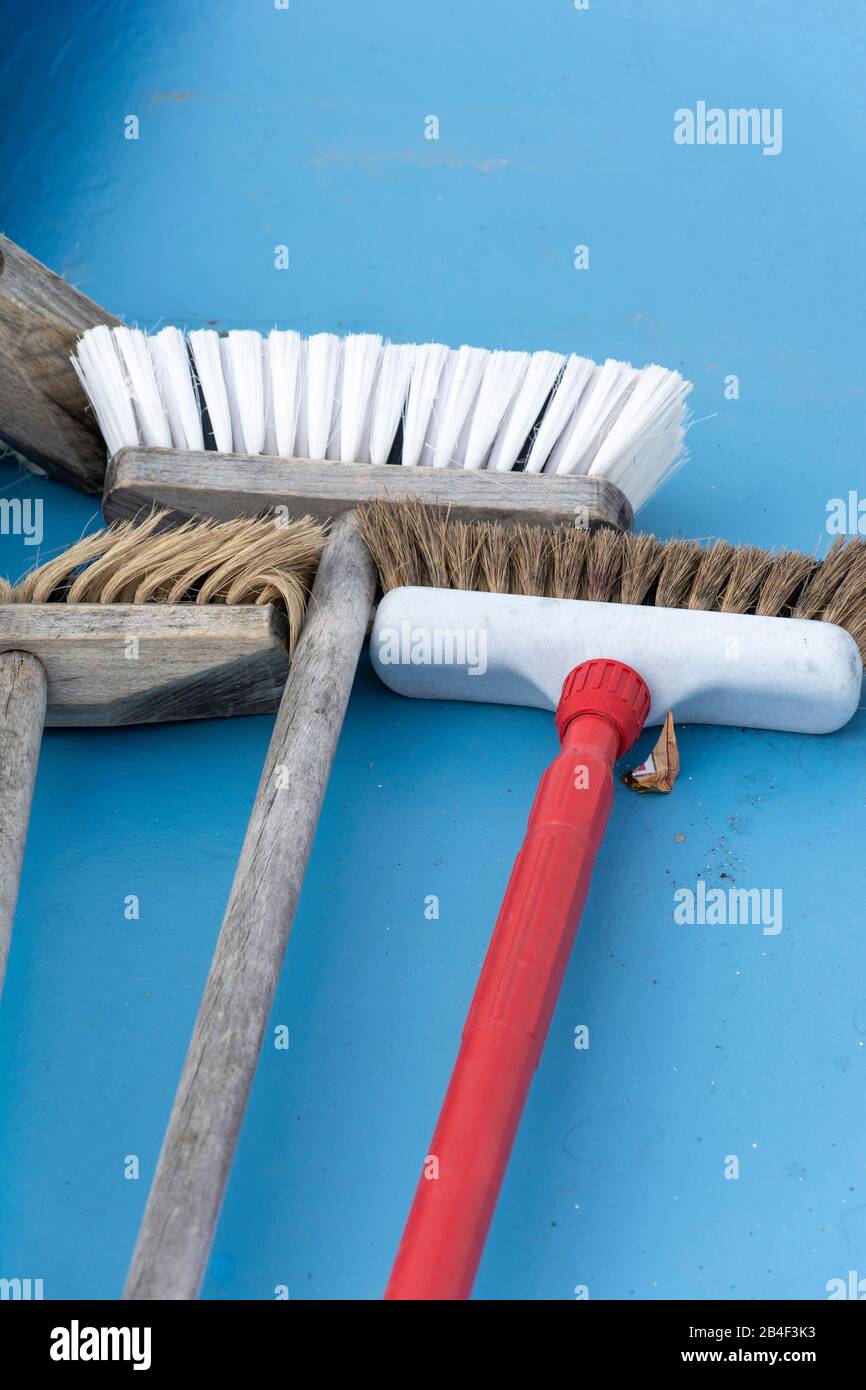 Brooms are lying on a blue floor Stock Photo