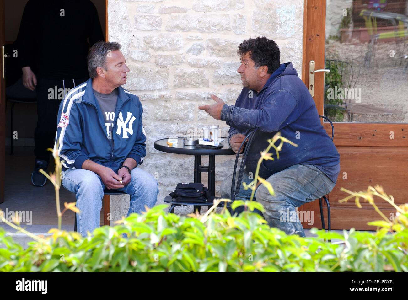 Twolocal Greeks conversing at the table, Greece Stock Photo
