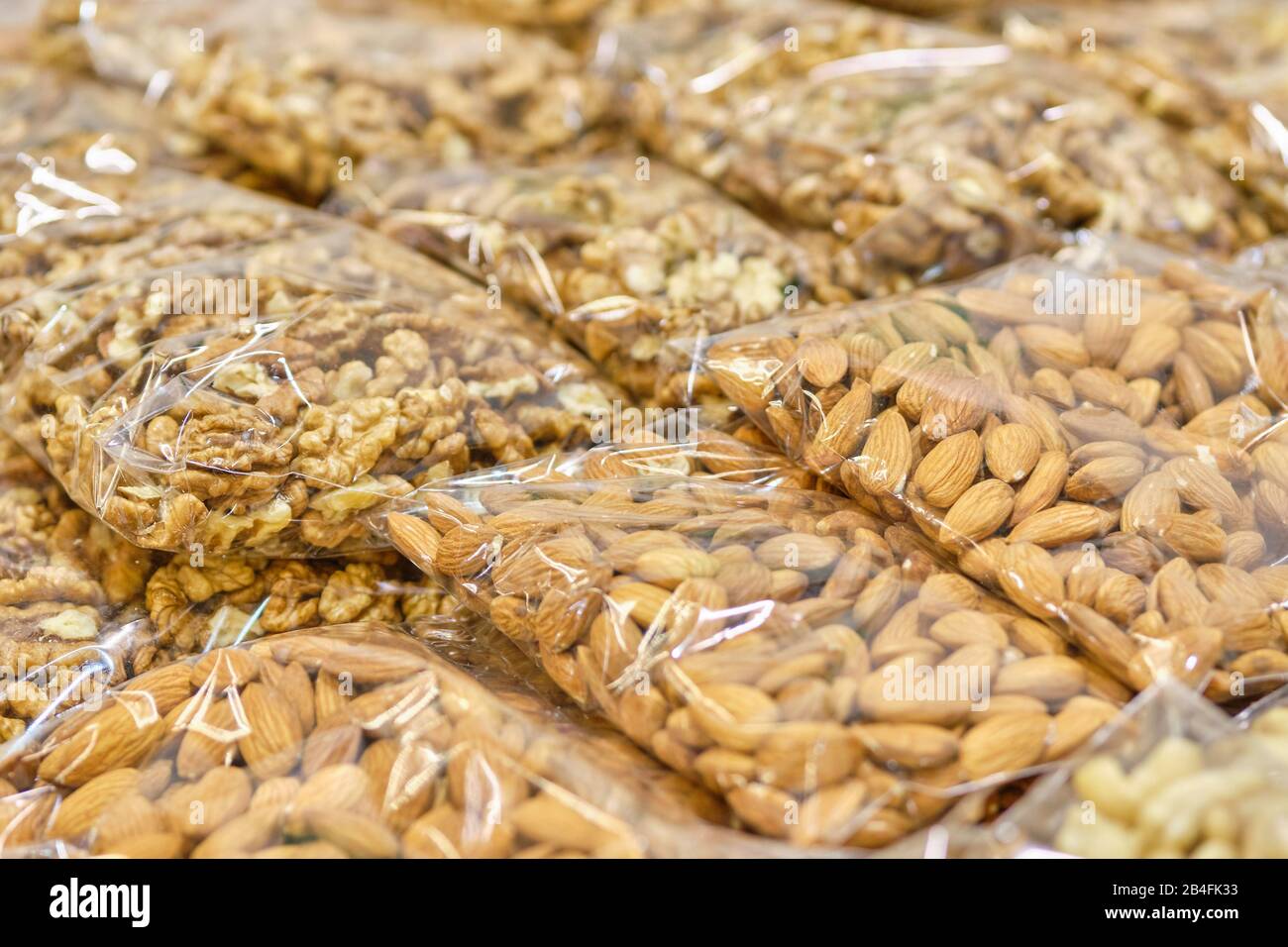 Packaging from a transparent bag with almonds and walnuts. Close up. Stock Photo