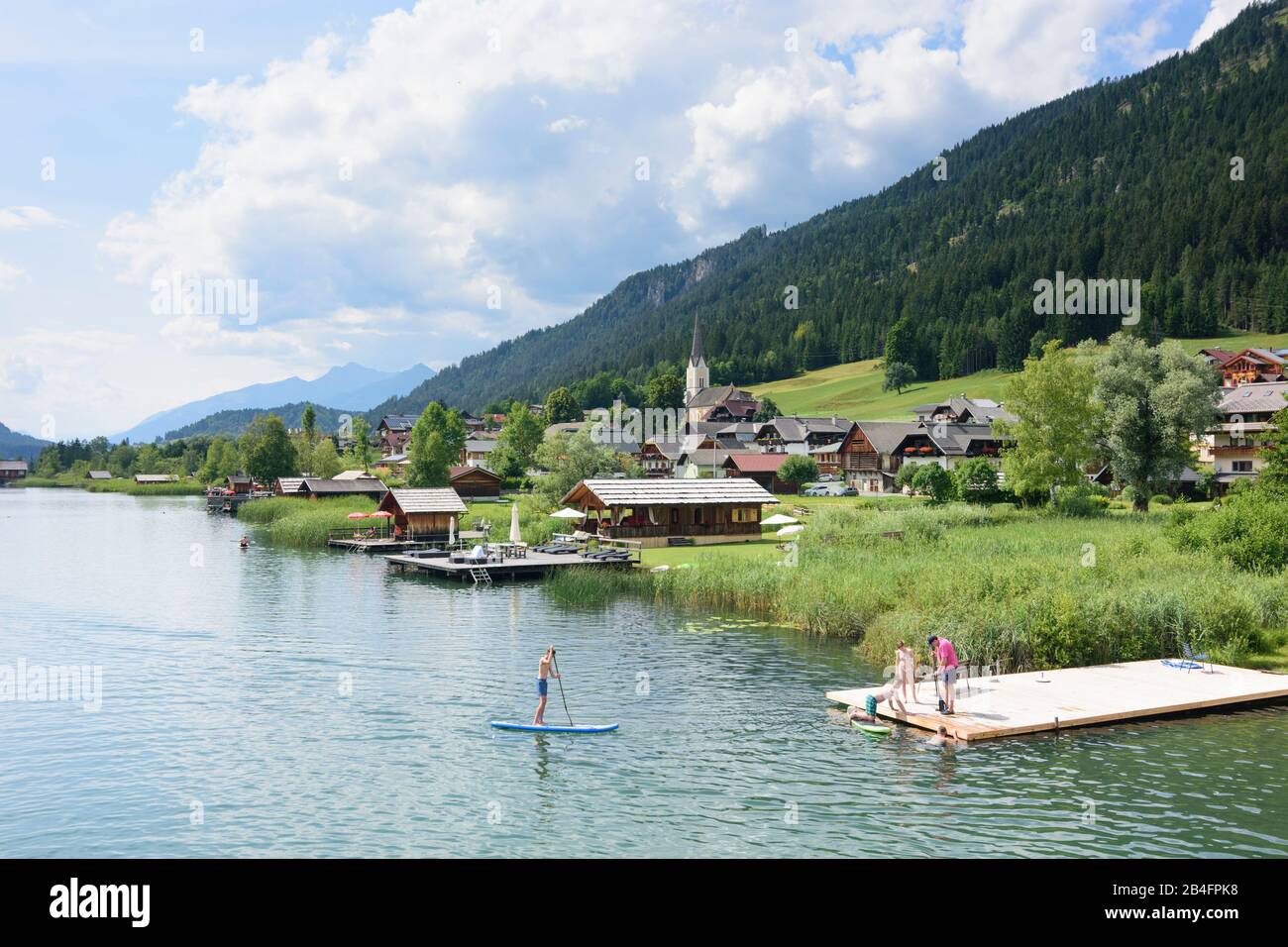 Weissensee, lake Weissensee, village and church Techendorf, bather, canoe, canoeist, rowing boat in Kärnten / Carinthia, Austria Stock Photo