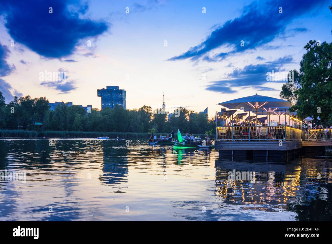 Wien / Vienna, oxbow lake river Alte Donau (Old Danube), sunset, wooden platform, people, floating restaurant, boat in 22. Donaustadt, Wien, Austria Stock Photo