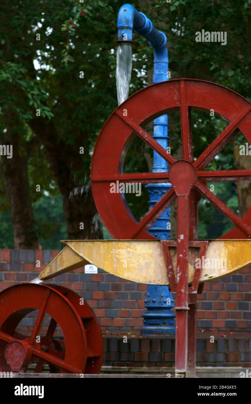 The sculpture of a mill wheel which is driven by water. Stock Photo