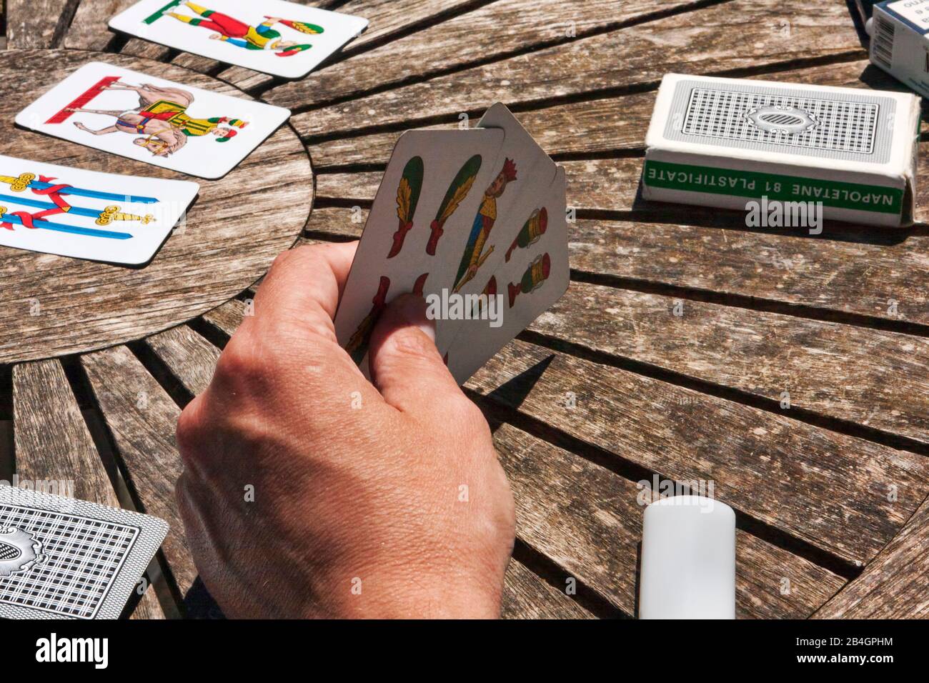 Turin, Italy - May 15, 2014: During coffee break, the employees play Trump with typical Neapolitan cards on a wooden table, first-person view on the g Stock Photo