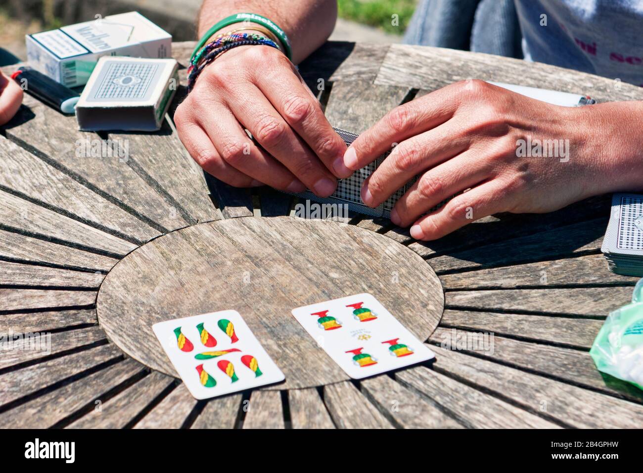 Turin, Italy - May 15, 2014: During coffee break, the employees play Trump with typical Neapolitan cards on a wooden table. Stock Photo