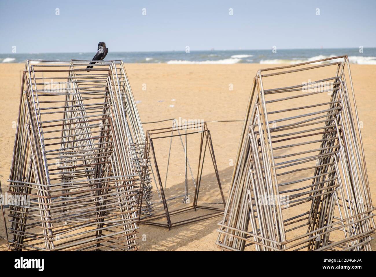 Metal racks on a stand with sea on which a raven sits Stock Photo