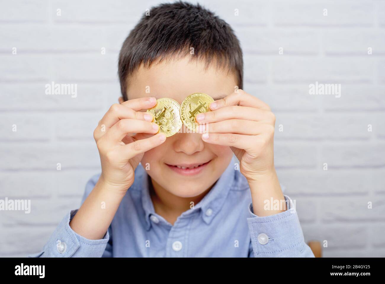 Little boy holding Bitcoin coin. Coin Focus. Child holding cryptocurrency  in metal. Mining or blockchain technology. crypto currency. child plays in  b Stock Photo - Alamy