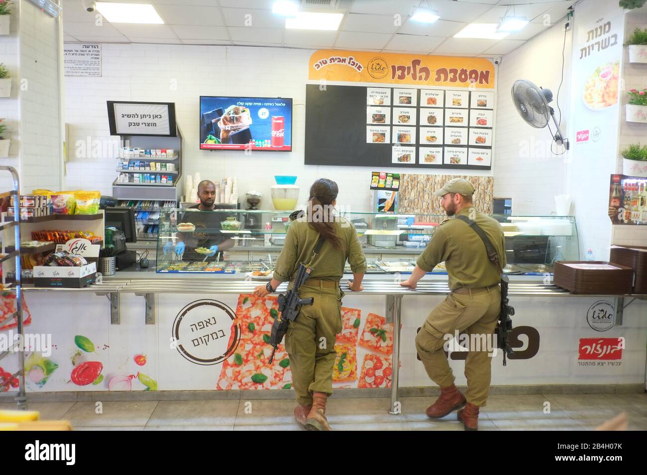 Israeli Defence Forces members getting coffee during break. Israeli men and women are all required to undergo three years of military service Stock Photo