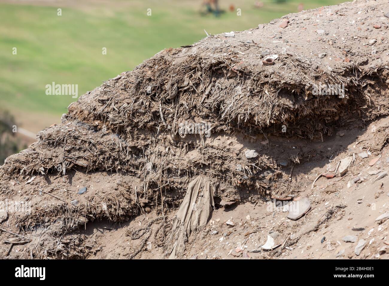 fragments of cloth and bone remains from past civilizations laying on the desert sand in the archeological site of Pachacamac, Peru. Stock Photo