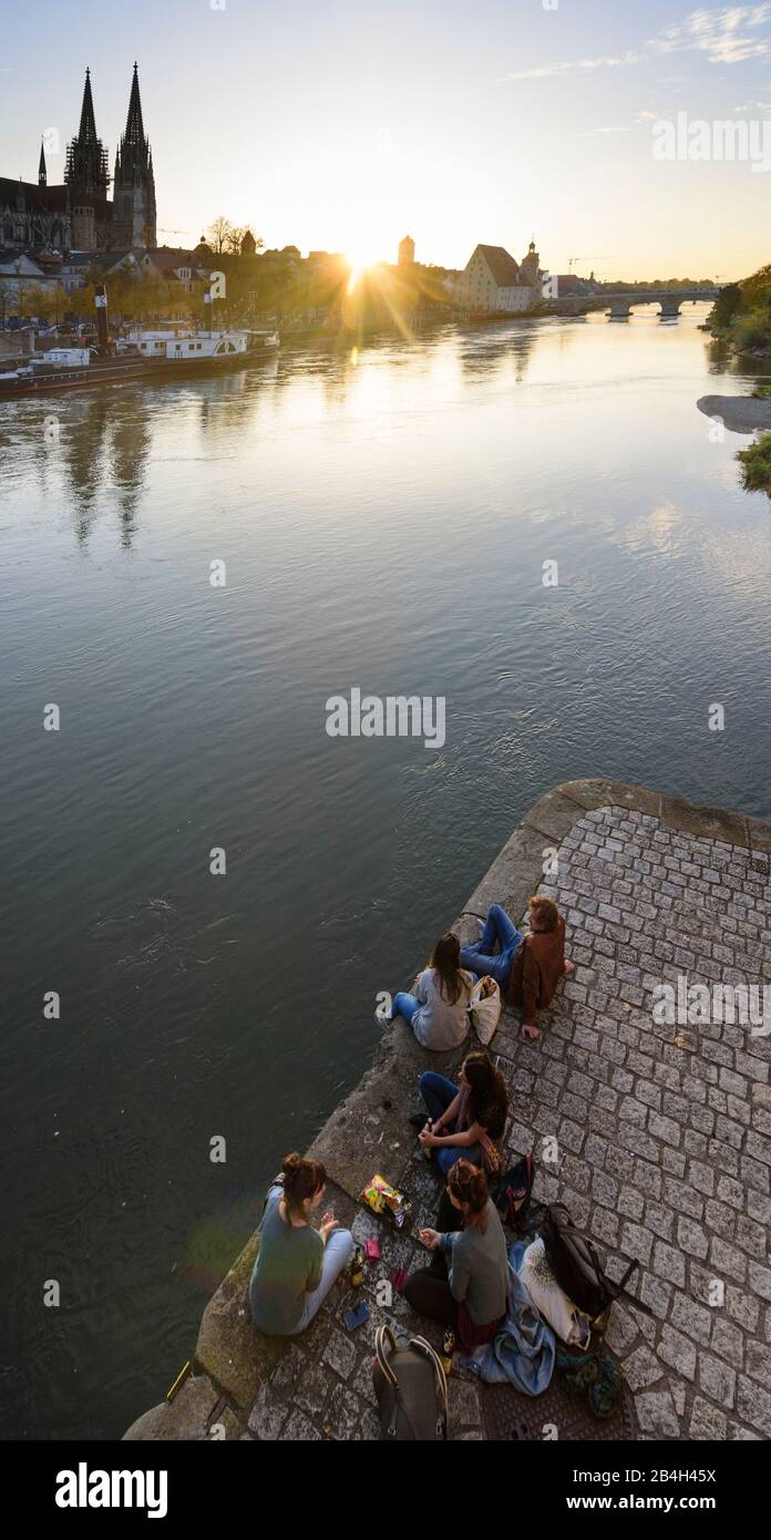 Regensburg, Danube, Stone Bridge, St. Peter's Church, Regensburger Dom, museum ship Ruthof, young people sitting on the river in conversation, Germany, Bavaria, Upper Palatinate Stock Photo