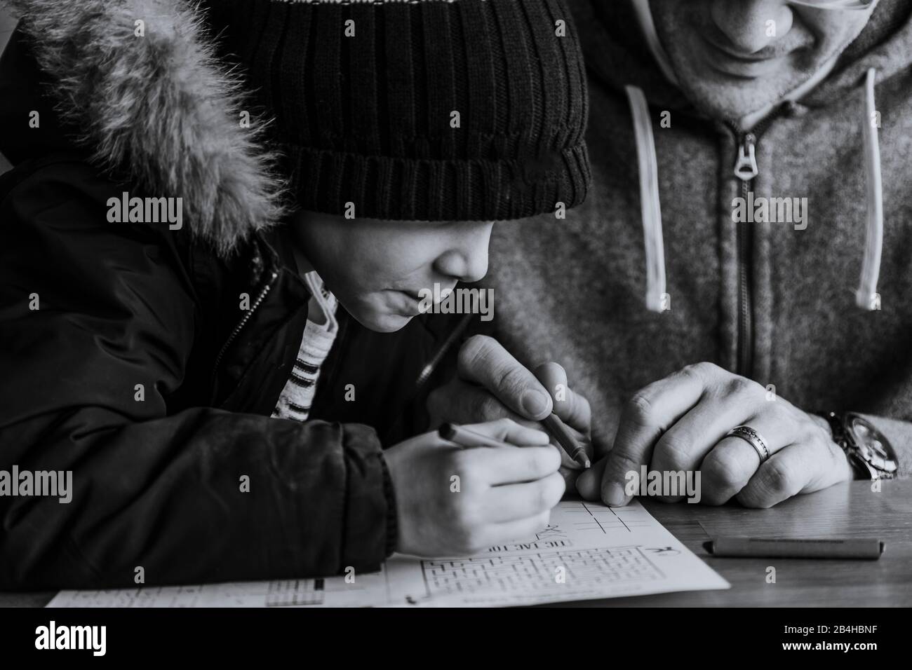 Black and white close up of father and son colouring at table Stock Photo