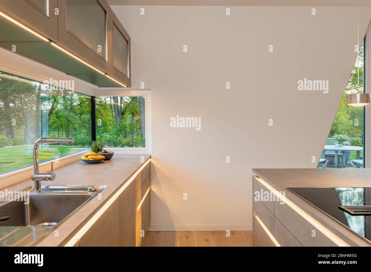 moderne Küche mit LED Band und Ausblick ins Grüne Stock Photo