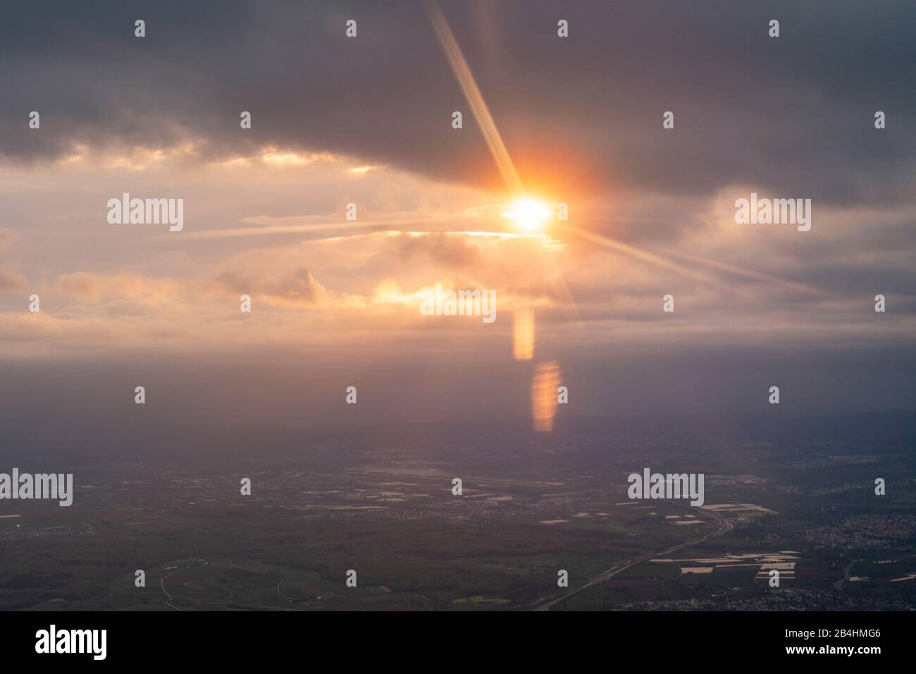 View from the window of an airplane at sunset with impressive light play over southern German landscape Stock Photo