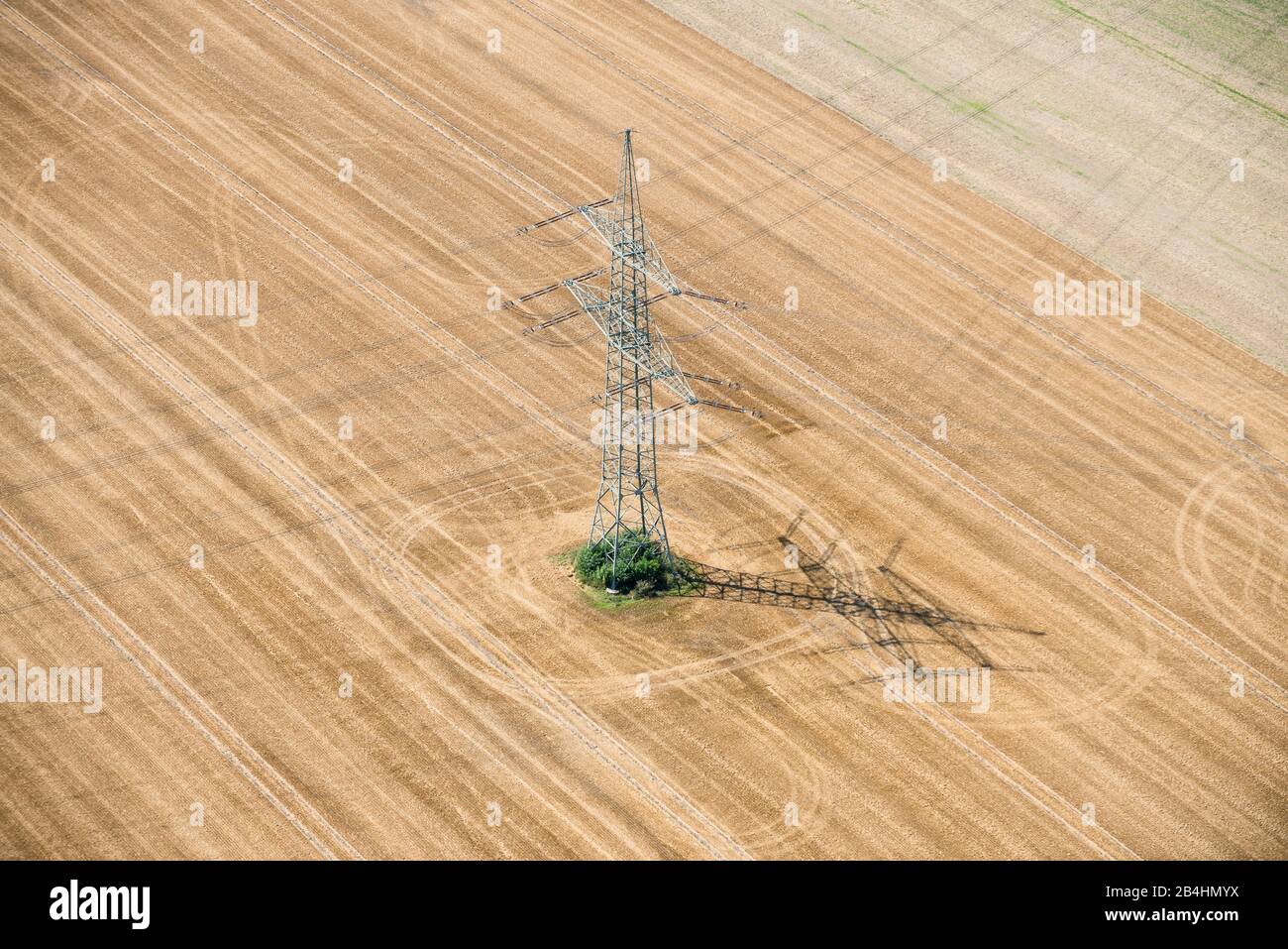 Luftaufnahme von einem Strommast auf abgeerntetem Getreidefeld Stock Photo