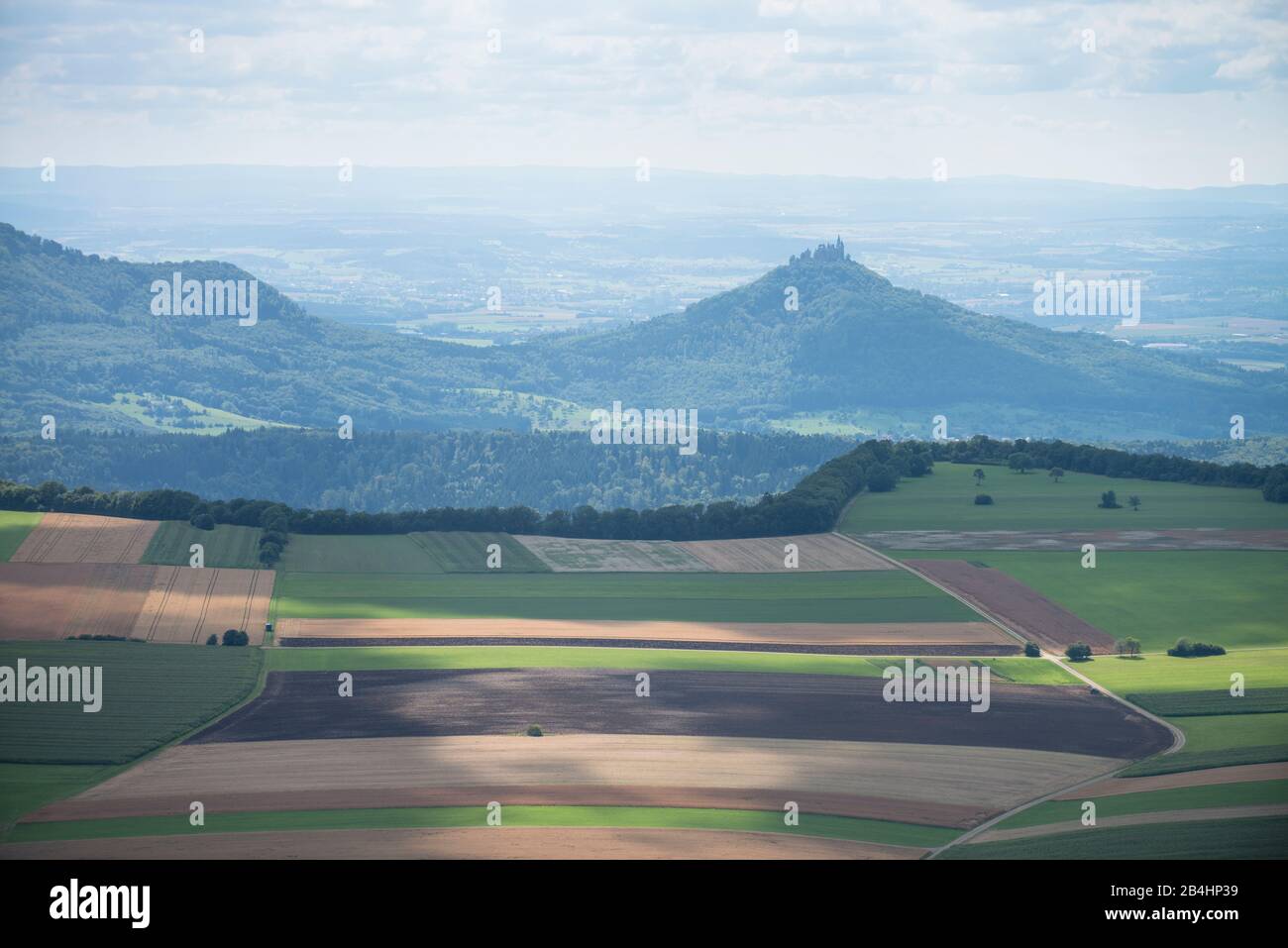 Luftaufnahme von Landschaft mit Wald landwirtschaftlich genutzen Feldern und Äckern und einer Burgruine im Hintergrund Stock Photo