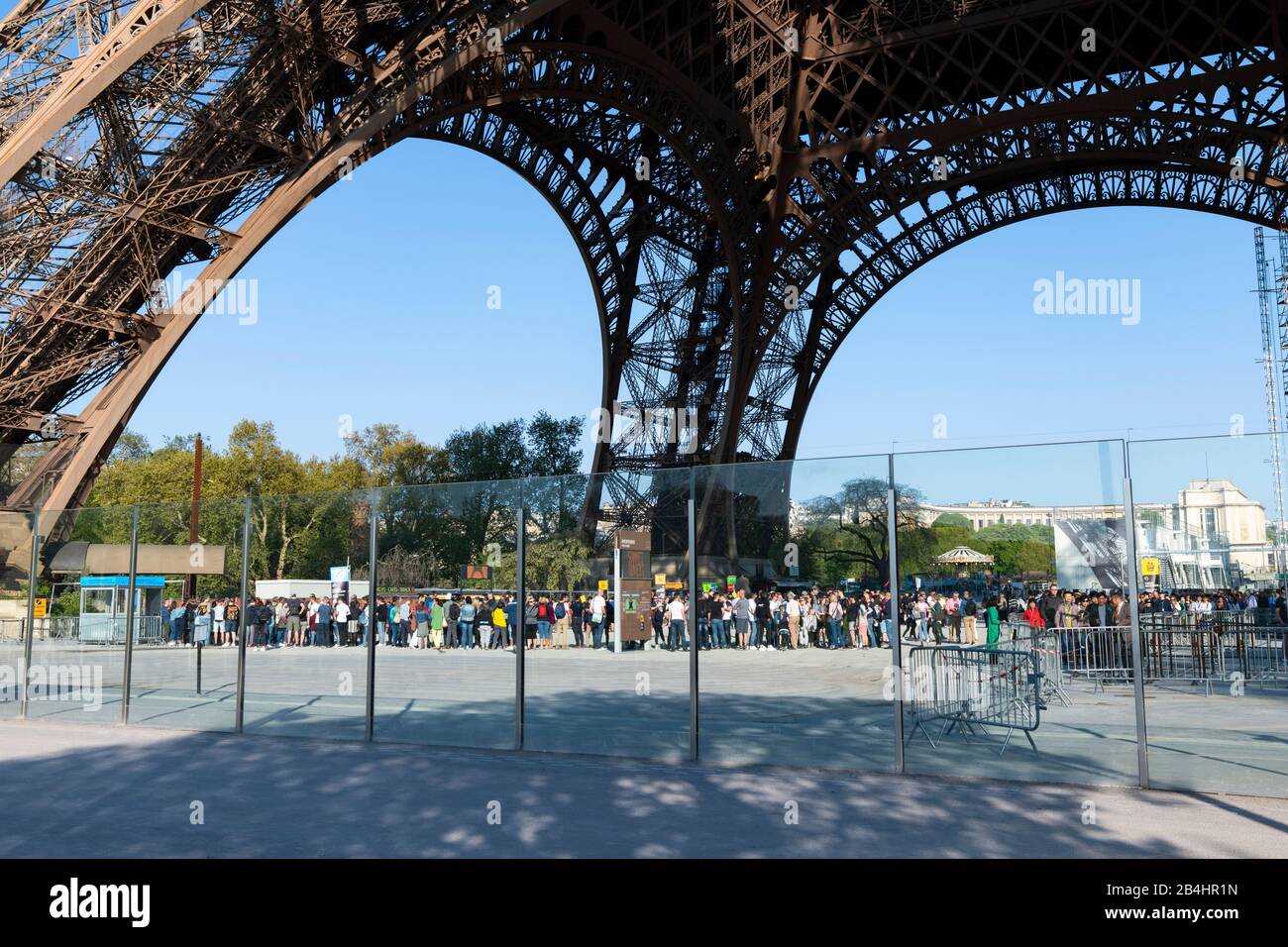 Wartende Touristen stehen unter dem Eiffelturm und warten auf den Einlass zum Lift, Paris, Frankreich, Europa Stock Photo