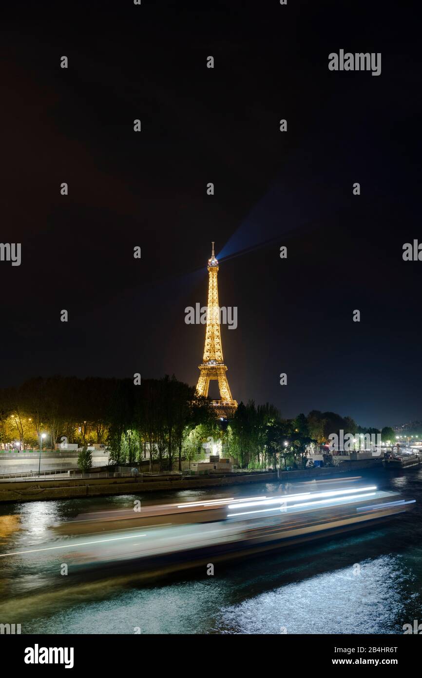 ein Ausflugsdampfer hinterläßt vor dem erleuchteten Eiffelturm eine Lichtspur, Paris, Frankreich, Europa Stock Photo