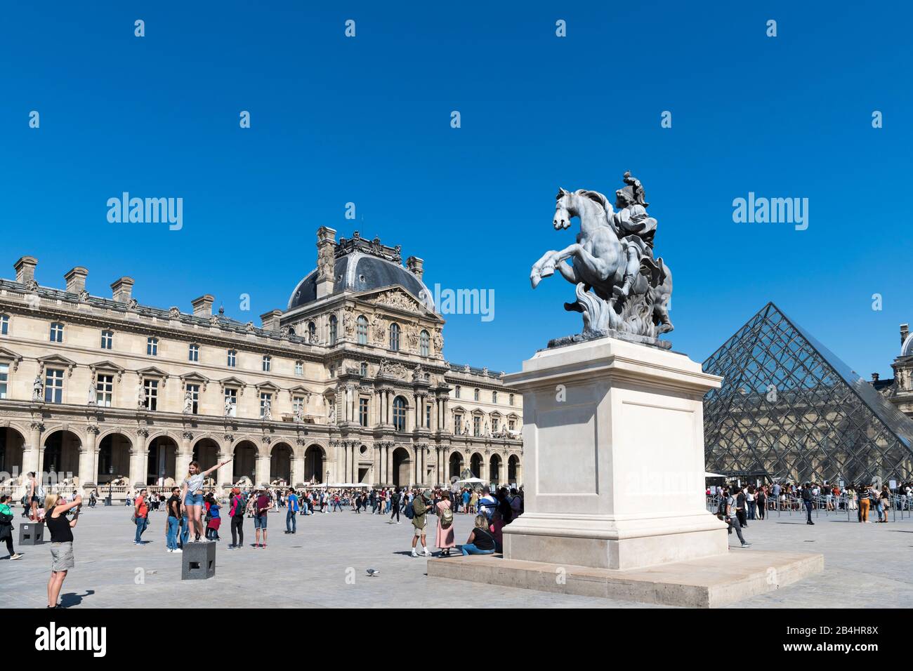 Tourists in front of the Musee du Louvre, the glass pyramid and the equestrian statue of King Louis XIV, Paris, France, Europe Stock Photo
