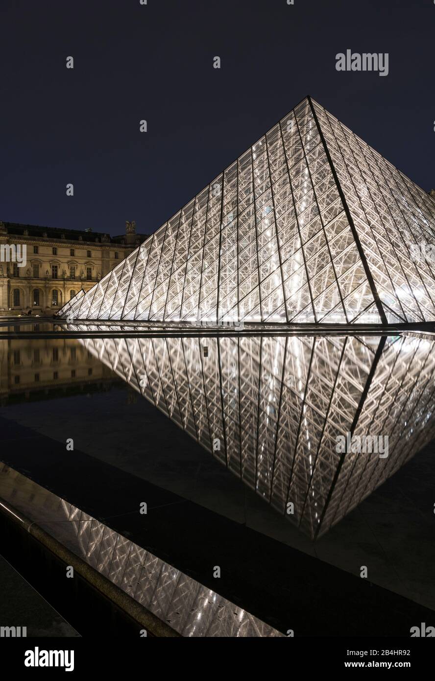Glass pyramid illuminated at night in the Louvre reflected in the water, Paris, France, Europe Stock Photo