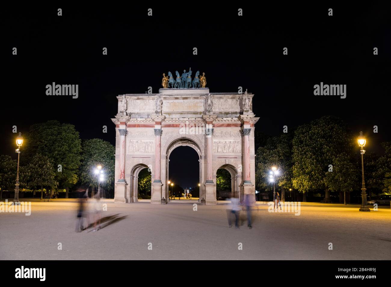 Touristen am nachts beleuchteter Arc de Triomphe du Carrousel mit Quadriga am Louvre, Paris, Frankreich, Europa Stock Photo